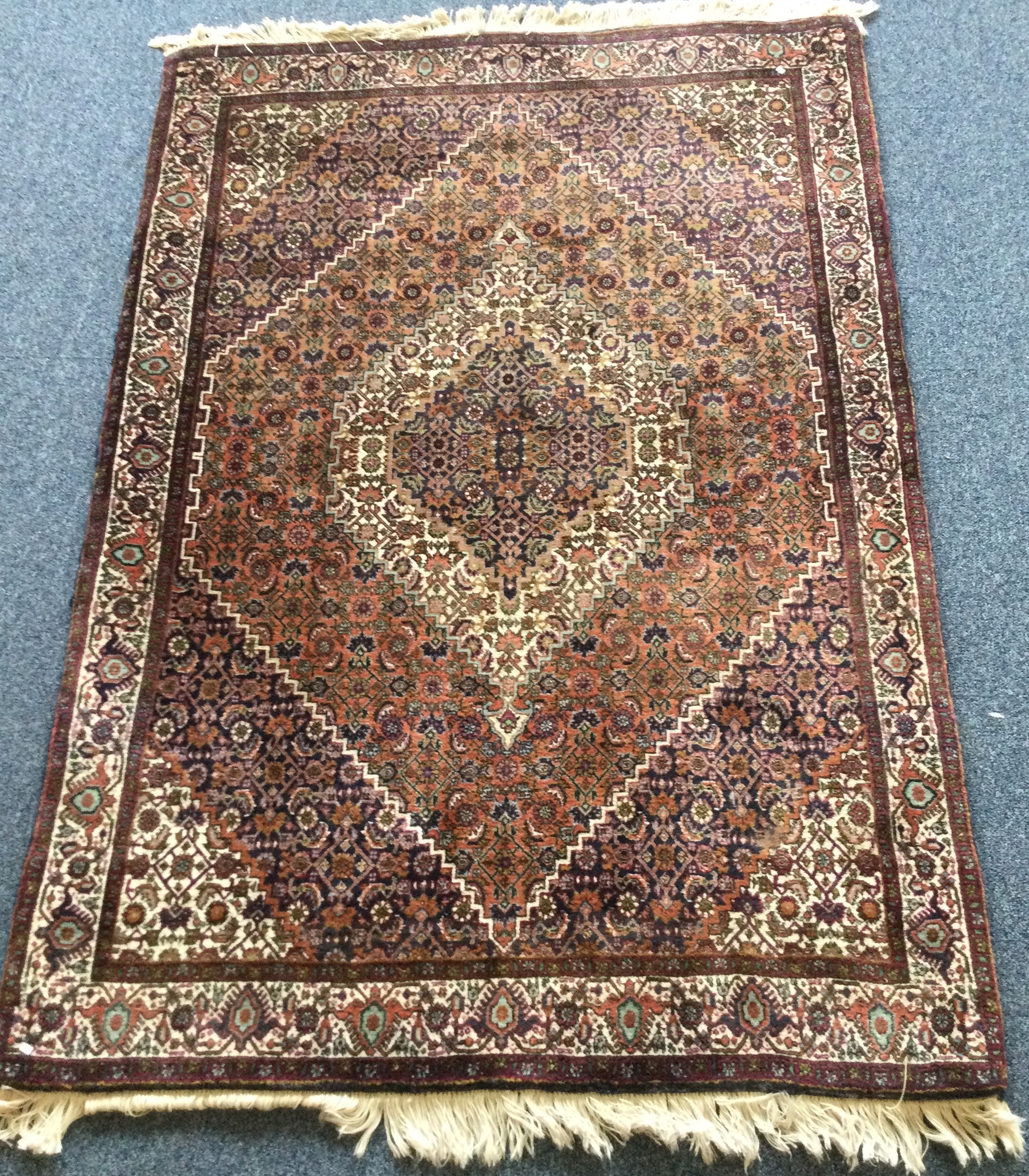 A good quality small rug decorated in bright colours.