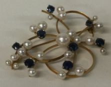 A heavy sapphire and pearl brooch set in 18 carat gold.