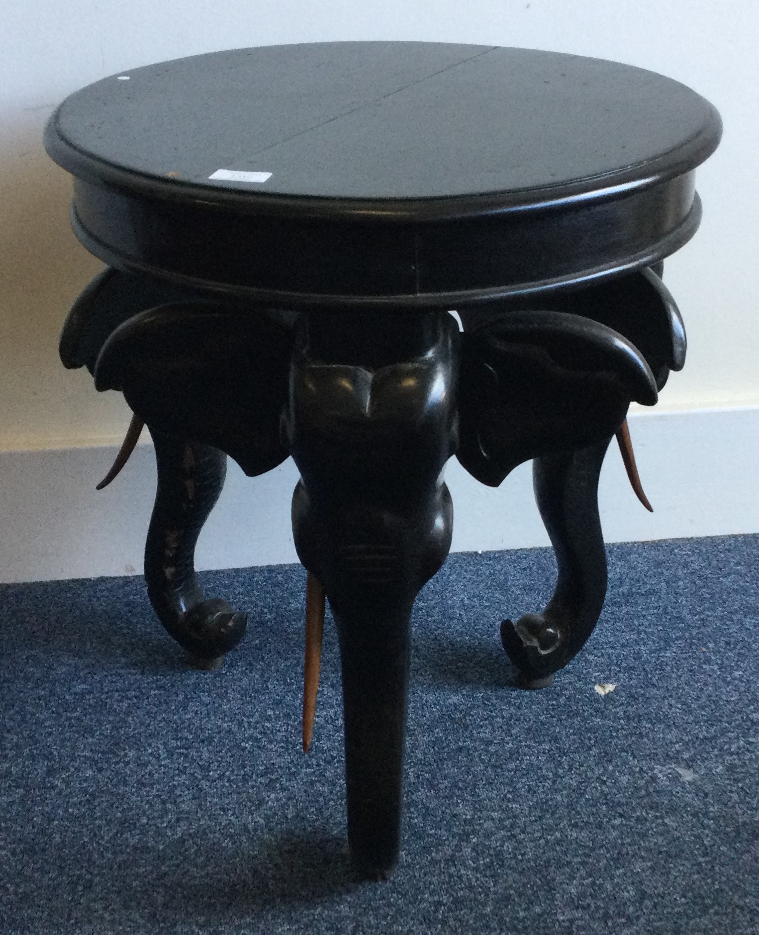 An unusual circular ebony table decorated with animals.