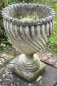 An unusual fluted garden vase on square base.