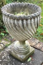 An unusual fluted garden vase on square base.