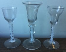 Three good Georgian air-twist glasses of typical form to pedestal base.