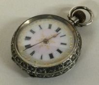 A small silver fob watch with white enamelled dial.