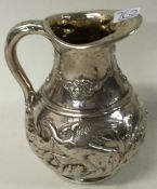 A fine chased Victorian silver jug embossed with birds.