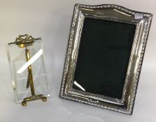 A silver mounted arched top picture frame with twisted decoration together with one other.