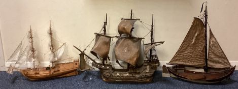 Three old wooden model boats.