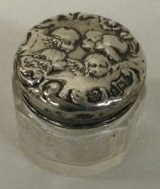 A silver and glass box decorated with cherubs.