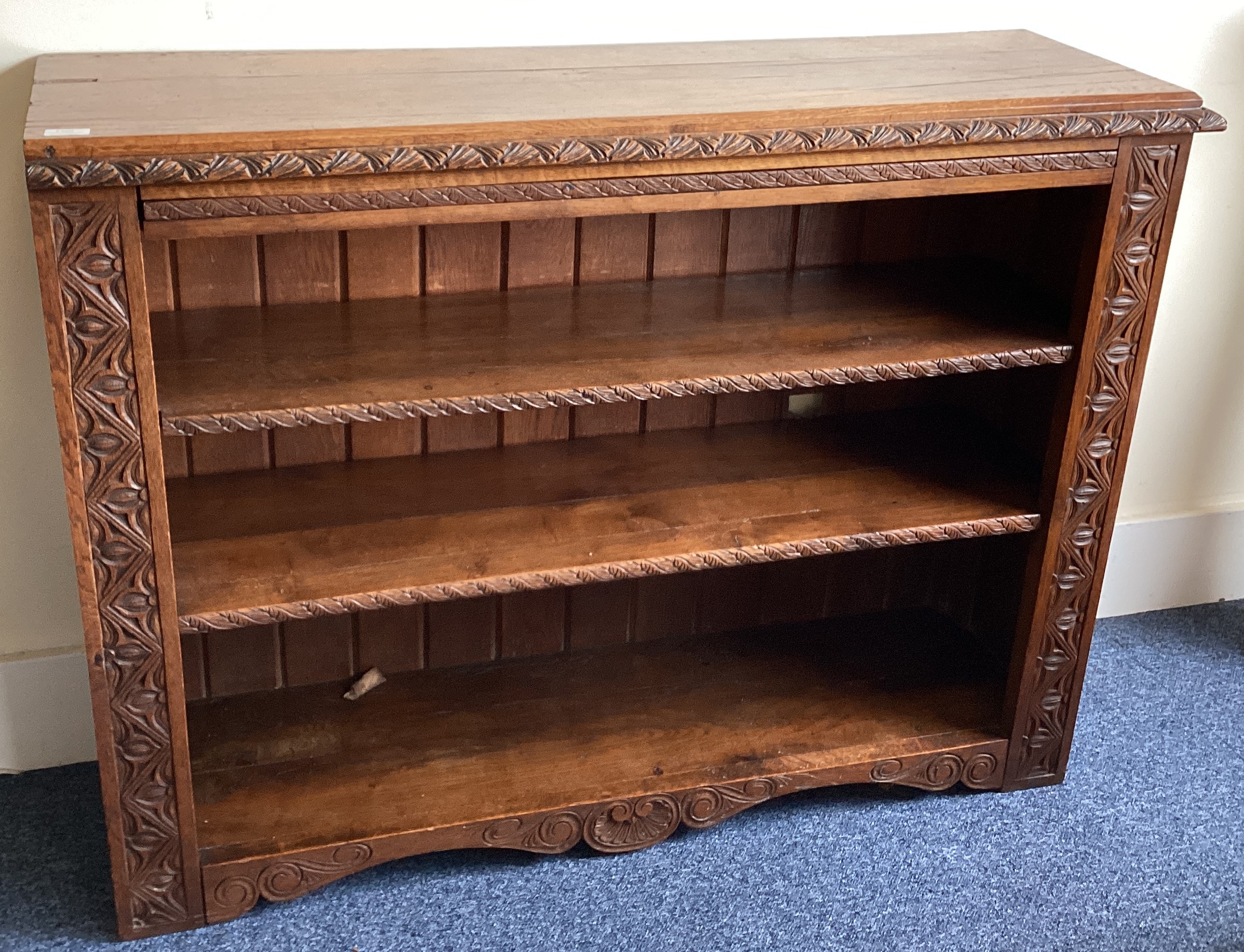 A heavy carved oak book case with shell decoration.