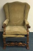 A Continental carved mahogany wing chair on turned
