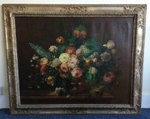 An oversized gilt framed canvas painting depicting still life with flowers.