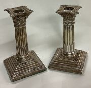 A pair of silver Corinthian candlesticks.