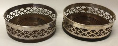 A pair of pierced silver coasters.