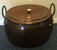 A large copper cooking pot and cover.