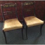 A pair of regency style brass inlaid dining chairs.