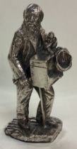 A large silver plated figure of a man with monkey.