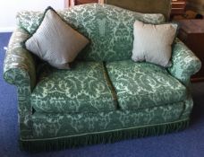 A good quality green two seater settee with tassel decoration.