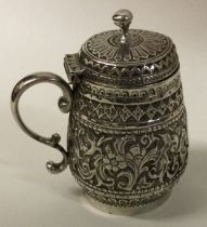 An Indian silver mustard pot chased with animals.