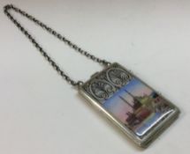 A silver and enamelled compact on suspended chain with scene of a mosque.