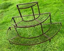 A wrought iron plant stand of circular form.