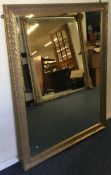 A large gilt framed rectangular wall mirror with scroll decoration.