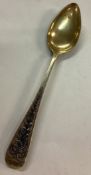 An early 19th Century silver gilt spoon engraved with scenes.
