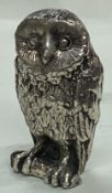 A silver plated figure of an owl.