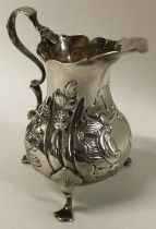 A fine 18th Century George III silver jug embossed with flowers.