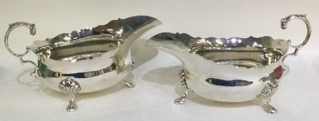 A pair of heavy Georgian style silver sauce boats with card cut rim.