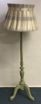 A painted green standard lamp. Est. £20 - £30.