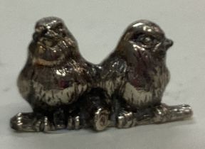 A silver plated figure of birds.