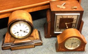 A group of three old wooden mantle clocks.