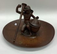 A heavy bronze inkwell in the form of a figure.