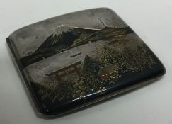 A Japanese silver and mixed metal cigarette case engraved with mountains and temples.