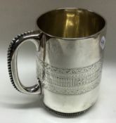 A Victorian silver bright-cut mug with beaded handle. London 1875. By William Hunter.
