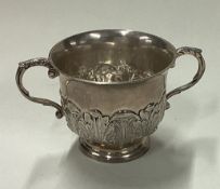 A silver chased porringer in the early style. Marked to base.