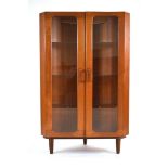 A 1970/80's Danish teak corner cabinet, the two glazed doors enclosing three glass shelves, on