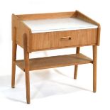 A 1960's Danish oak bedside table with an aluminium surface, single drawer and circular tapering