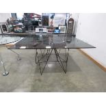 In the manner of Paolo Piva, a tubular dining table with a glass surface, 150 x 150 cm