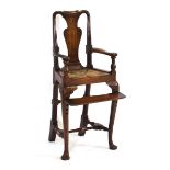 A 19th century oak child's highchair with a rush seat, fiddle splat and adjustable foot rest