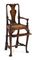 A 19th century oak child's highchair with a rush seat, fiddle splat and adjustable foot rest