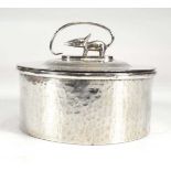 A hammered base metal trinket box and cover with stylised mouse finial in the Arts & Crafts