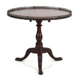 A late 18th/early 19th century mahogany tilt-top table, the circular surface with a metalwork