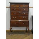 A George III walnut chest-on-stand, the dental cornice over an arrangement of two short over four