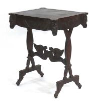 A Victorian oak and tooled leather library table with figural masks, royal emblems and flags, and