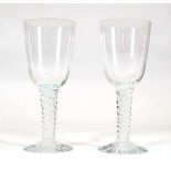 A pair of oversized glass drinking glasses with twisted stems
