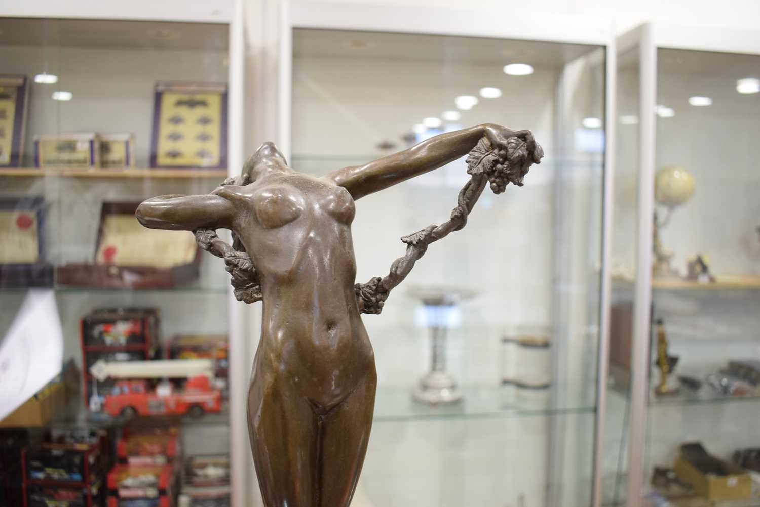 A bronze figure in the Art Deco manner modelled as a nude female standing on a rock holding vines, - Image 3 of 6