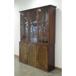A late 19th century walnut bookcase cabinet, the three glazed doors enclosing adjustable shelves