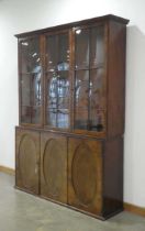 A late 19th century walnut bookcase cabinet, the three glazed doors enclosing adjustable shelves