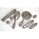 Eight Edwardian and later silver mounted dressing table items comprising a hand mirror, two