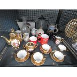 Cage containing lusterware, coffee mugs and a camera